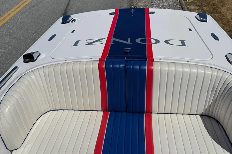 Slide: The Image of 2002 Donzi 22 Classic boat with white, blue, and red striped seating. - 7