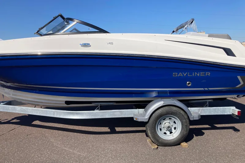 The Image of 2025 Bayliner VR5 Bowrider I/O boat on trailer, blue and white design. - 0