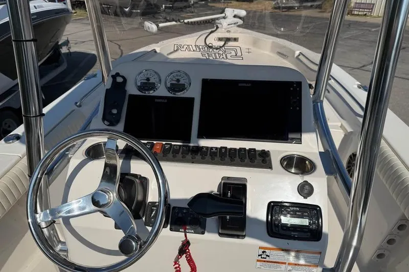 Slide: The Image of 2018 Carolina Skiff 23LX boat dashboard with steering wheel and control panel. - 11