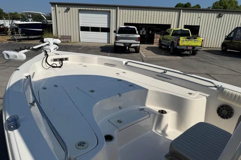 Slide: The Image of 2018 Carolina Skiff 23LX boat at a marina with parked vehicles. - 15