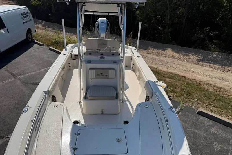 Slide: The Image of 2018 Carolina Skiff 23LX boat with seating and console, parked outdoors. - 18
