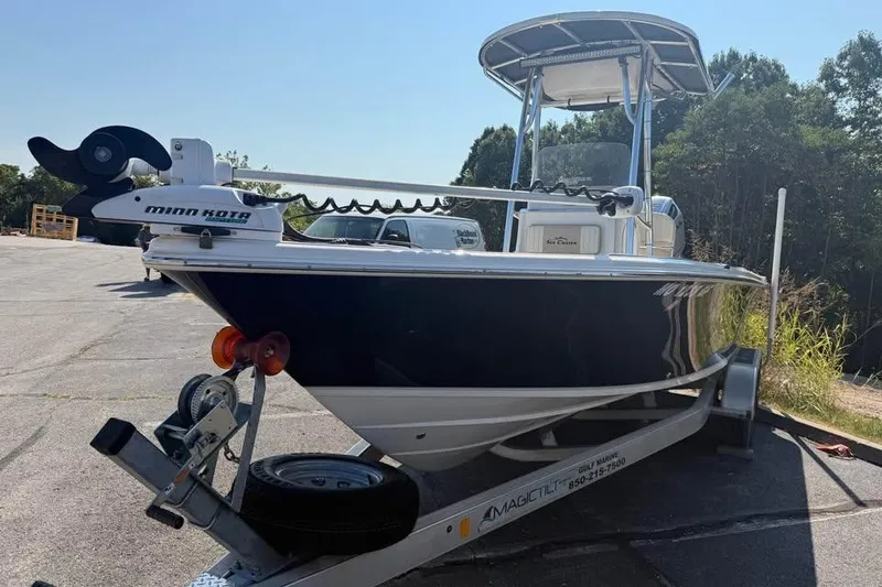 Slide: The Image of 2018 Carolina Skiff 23LX boat on trailer with Minn Kota motor, parked outdoors. - 4