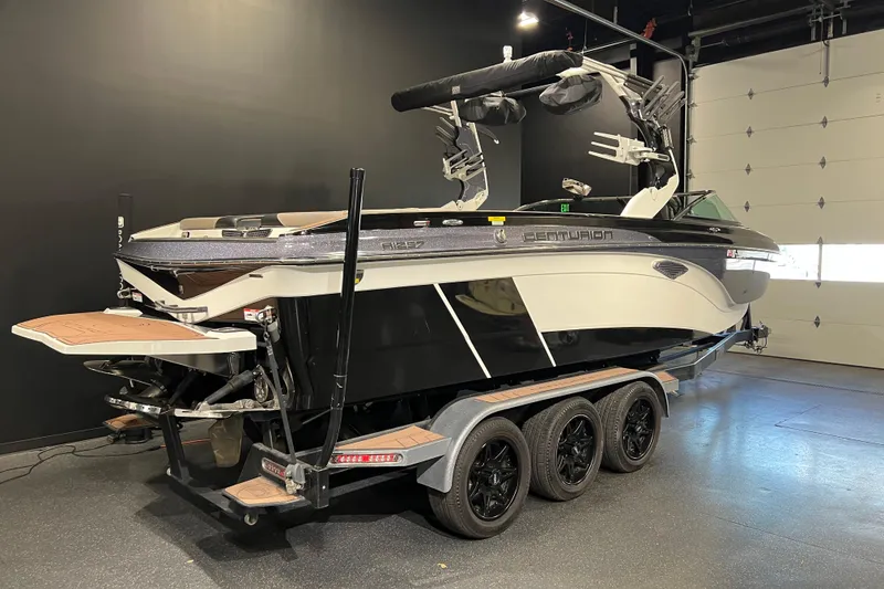 Slide: The Image of 2017 Centurion Ri257 boat on trailer in showroom, black and white design. - 3