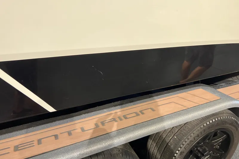 Slide: The Image of 2017 Centurion Ri257 boat on trailer, showcasing sleek black and white design. - 9