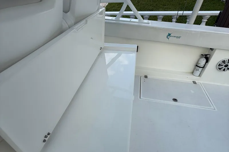 Slide: The Image of 2021 Marlin 39 CC boat interior with storage bench, fire extinguisher, and speaker. - 12