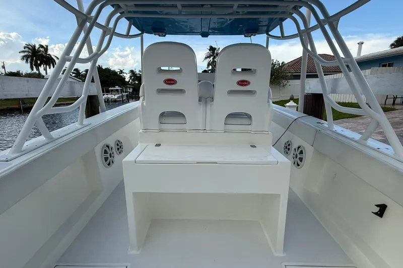 Slide: The Image of 2021 Marlin 39 CC boat interior with dual seats and speakers, docked by a canal. - 15