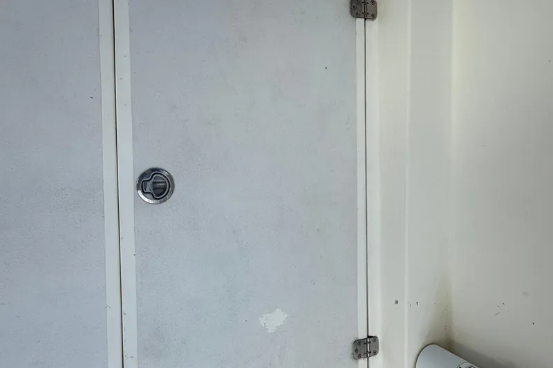 Slide: The Image of 2021 Marlin 39 CC boat interior with white panel and metal latch. - 16