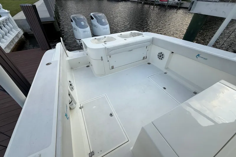 Slide: The Image of 2021 Marlin 39 CC boat deck with Suzuki engines, docked by the water. - 20