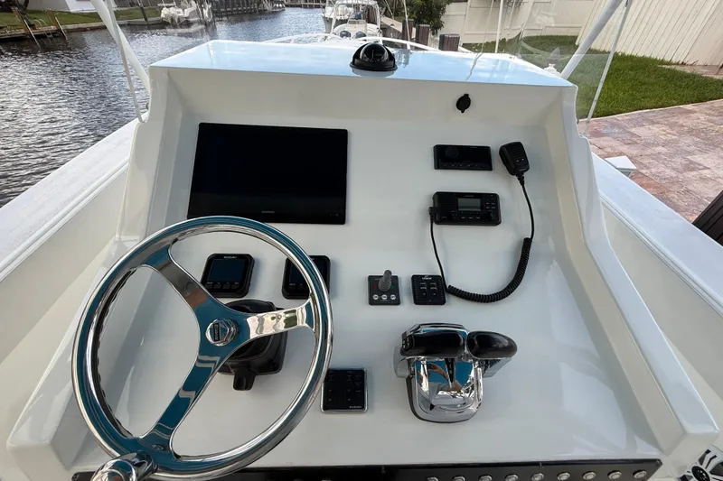Slide: The Image of 2021 Marlin 39 CC boat dashboard with steering wheel and electronic controls. - 23