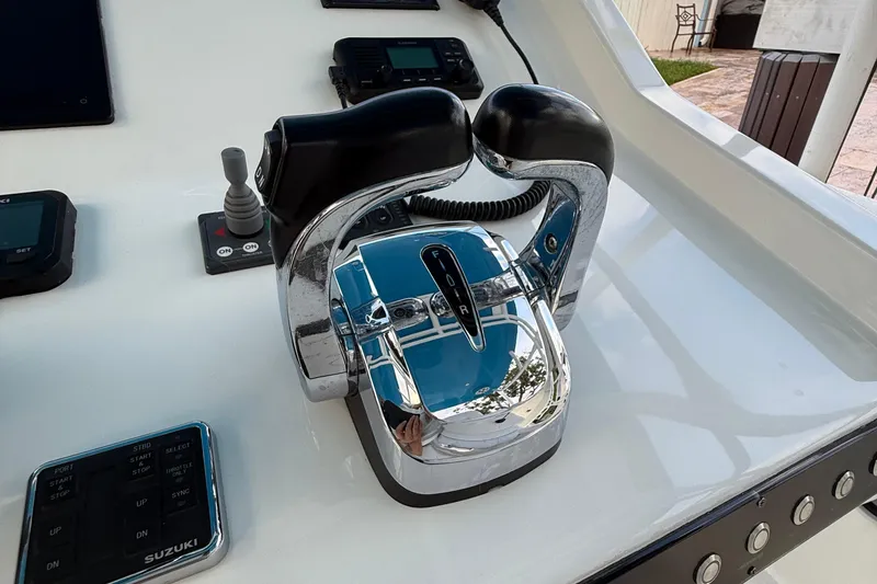 Slide: The Image of Control panel of 2021 Marlin 39 CC boat with chrome throttle and Suzuki controls. - 28