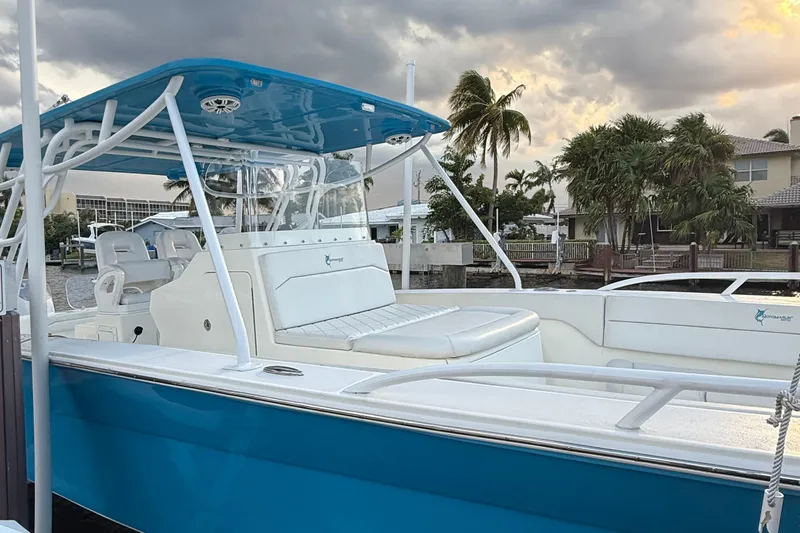 Slide: The Image of 2021 Marlin 39 CC boat with blue hull and white seating, docked near palm trees. - 3
