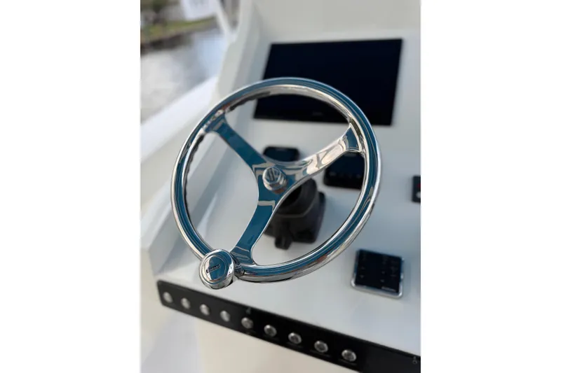Slide: The Image of Steering wheel of 2021 Marlin 39 CC boat, featuring sleek chrome design. - 30