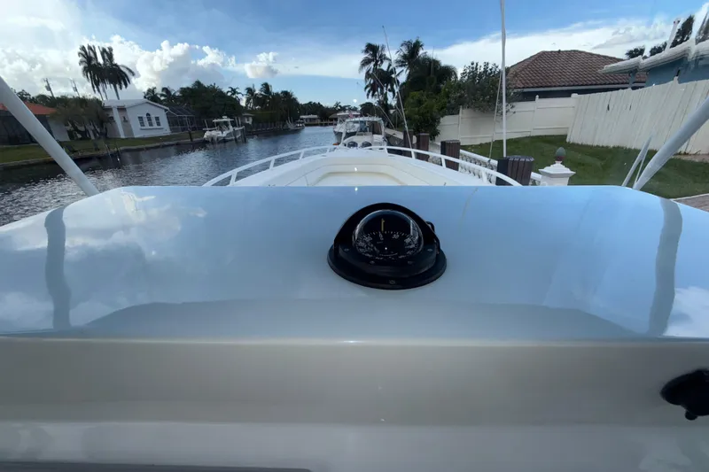 Slide: The Image of 2021 Marlin 39 CC boat with compass, docked in a scenic canal setting. - 36