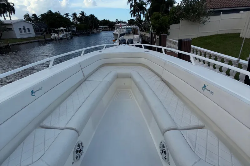 Slide: The Image of 2021 Marlin 39 CC boat interior with white cushioned seating, docked by a canal. - 50