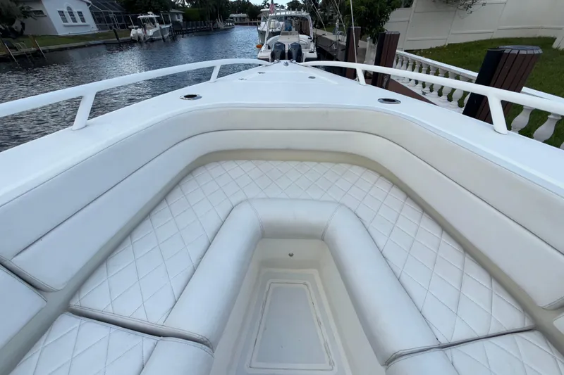 Slide: The Image of 2021 Marlin 39 CC boat with white cushioned seating, docked by a canal. - 53