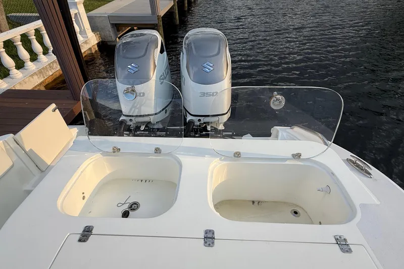 Slide: The Image of 2021 Marlin 39 CC boat with dual Suzuki 350 engines, docked by the water. - 6