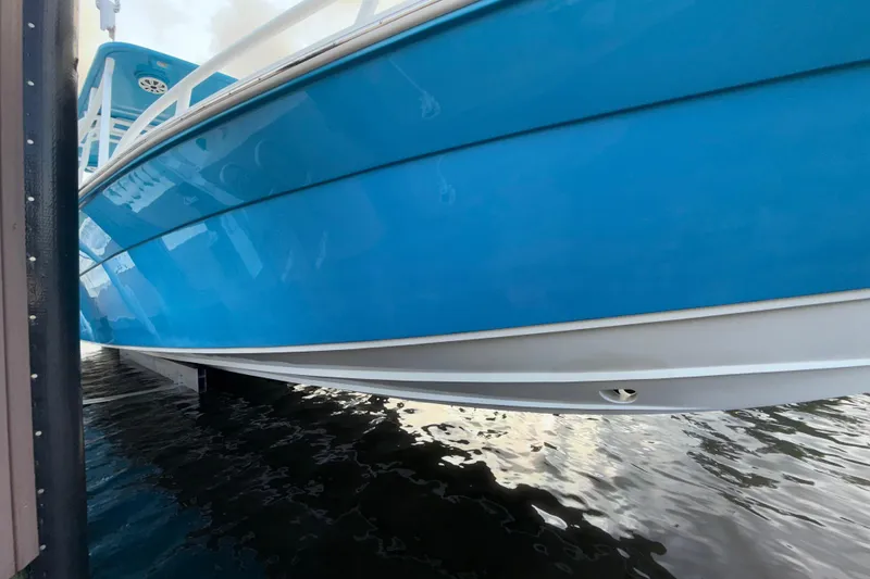 Slide: The Image of 2021 Marlin 39 CC boat with blue hull docked on water. - 72