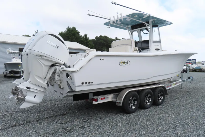 Slide: The Image of 2024 Sea Hunt Gamefish 30 Coffin Box boat on trailer, featuring Yamaha engines. - 2