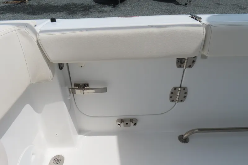 Slide: The Image of 2024 Sea Hunt Gamefish 30 Coffin Box interior detail with white cushioned seating and stainless steel hardware. - 34