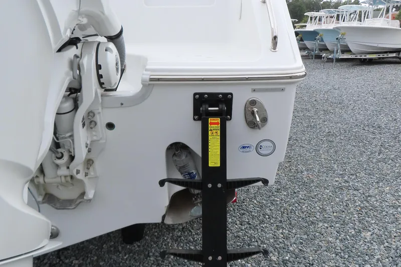 Slide: The Image of 2024 Sea Hunt Gamefish 30 Coffin Box boat stern with motor and safety labels. - 6