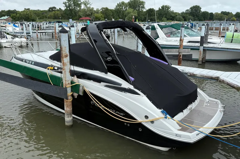 Slide: The Image of 2018 Crownline 264 CR boat docked at marina with black cover. - 16