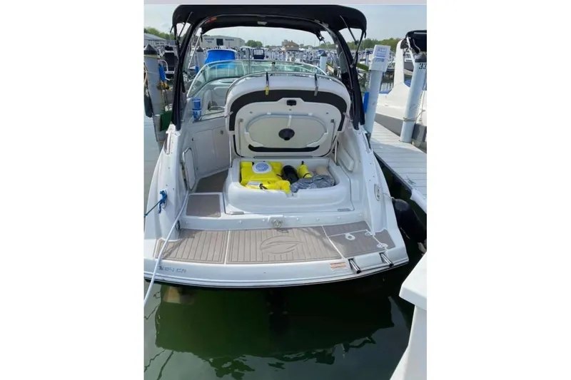 Slide: The Image of 2018 Crownline 264 CR boat docked, open storage compartment, marina background. - 3