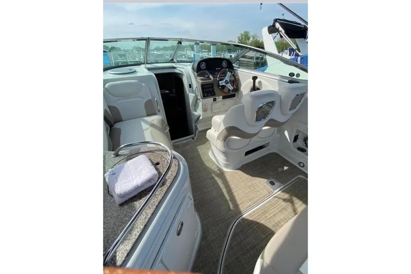 Slide: The Image of 2018 Crownline 264 CR boat interior with helm, seating, and cabin entrance. - 4