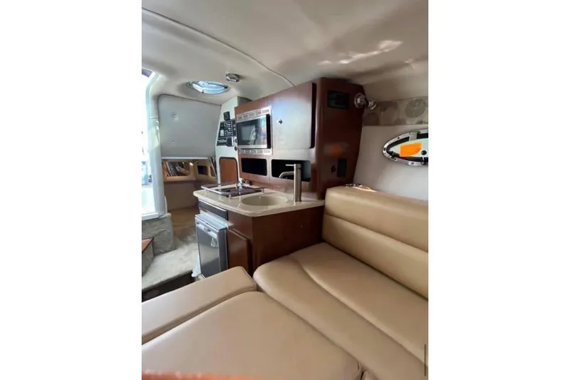 Slide: The Image of 2018 Crownline 264 CR cabin interior with kitchenette and seating area. - 6