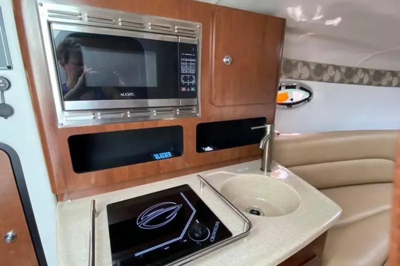 Slide: The Image of 2018 Crownline 264 CR boat interior with kitchenette, microwave, and sink. - 8