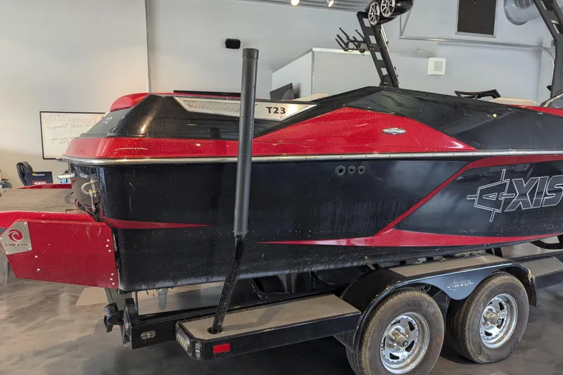 Slide: The Image of 2018 Axis T23 boat in showroom, red and black design on trailer. - 11