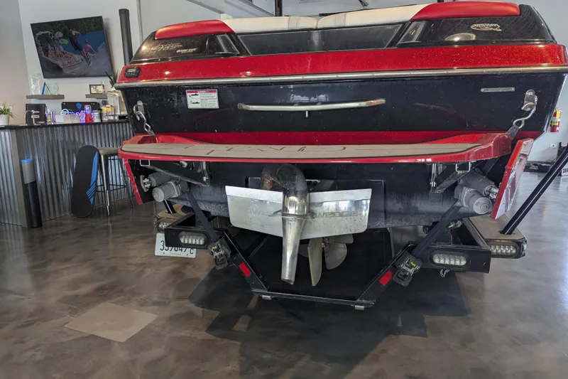 Slide: The Image of 2018 Axis T23 boat rear view in showroom, showcasing propeller and swim platform. - 13