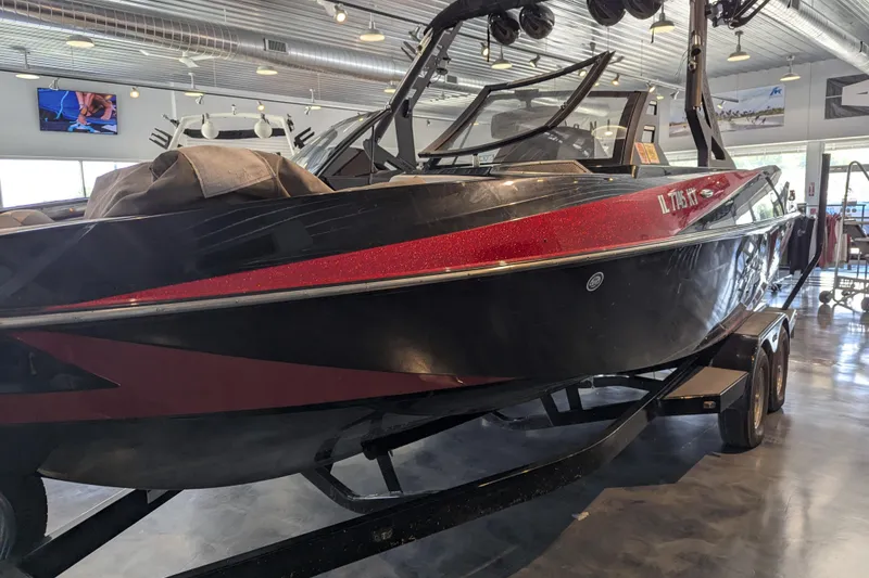 Slide: The Image of 2018 Axis T23 boat with red and black design in a showroom. - 16