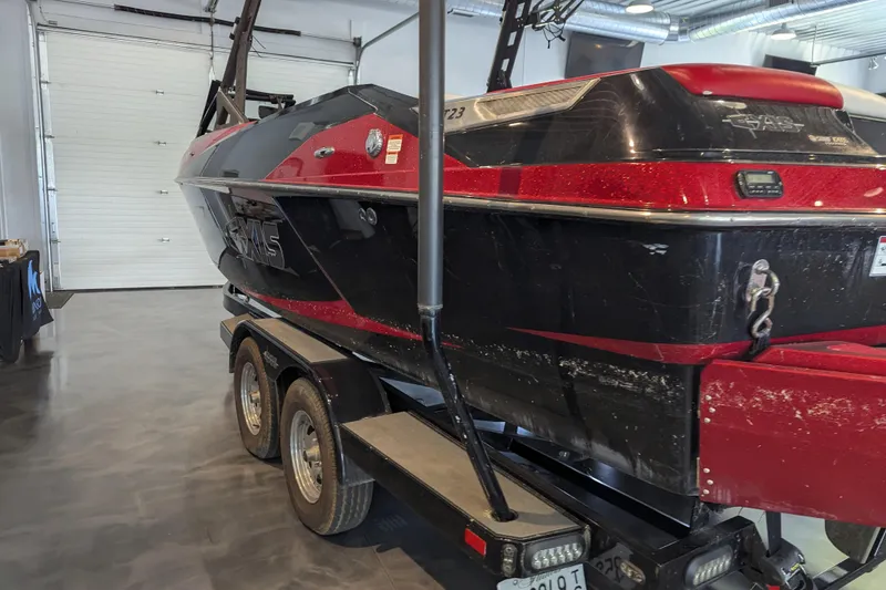 Slide: The Image of 2018 Axis T23 boat in a garage, red and black design on a trailer. - 17