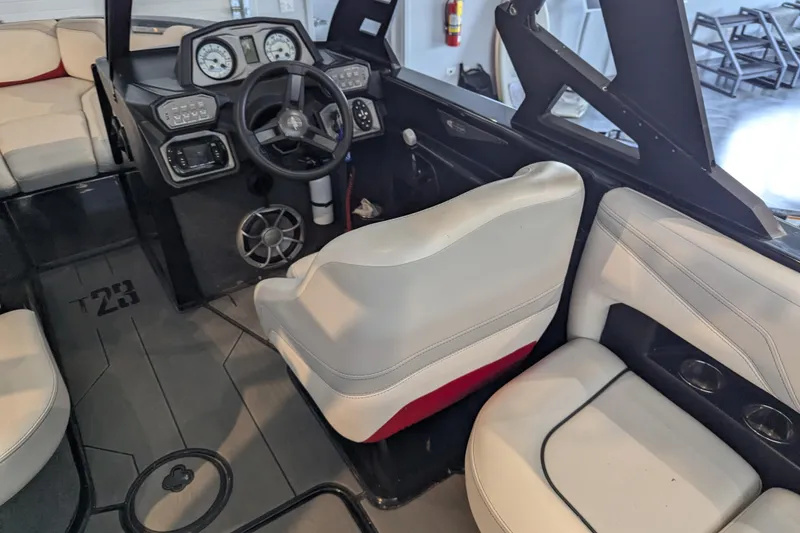 Slide: The Image of 2018 Axis T23 boat interior with steering wheel, dashboard, and seating. - 24