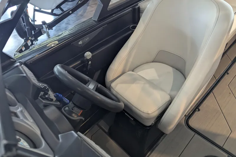 Slide: The Image of 2018 Axis T23 boat interior with steering wheel and beige captain's seat. - 25