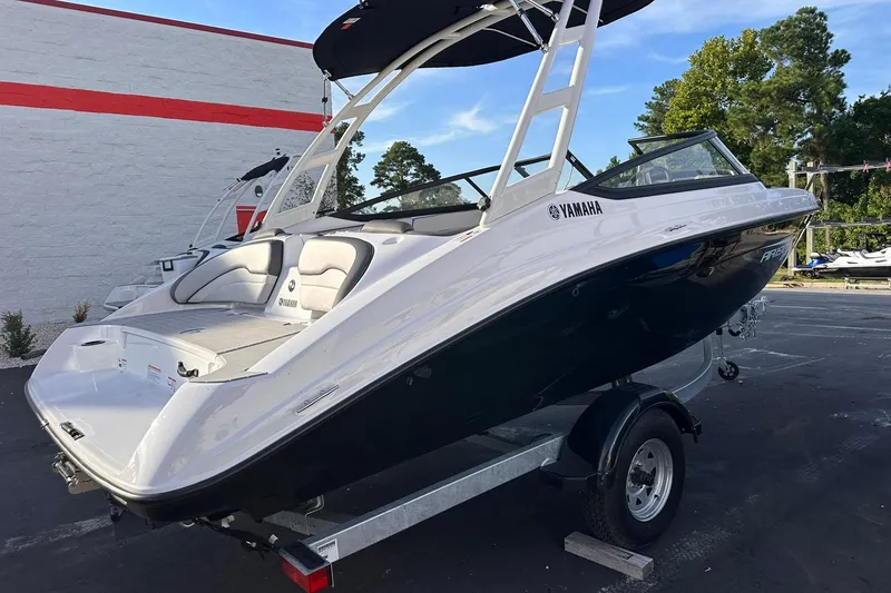 Slide: The Image of 2025 Yamaha Boats AR190 on trailer, sleek design, white and black exterior, parked outdoors. - 7