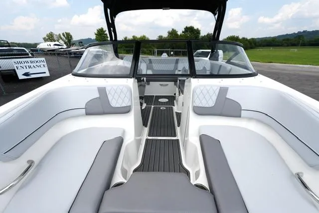 Slide: The Image of 2024 Bayliner VR5 Bowrider I/O with spacious seating and sleek design in a showroom setting. - 10