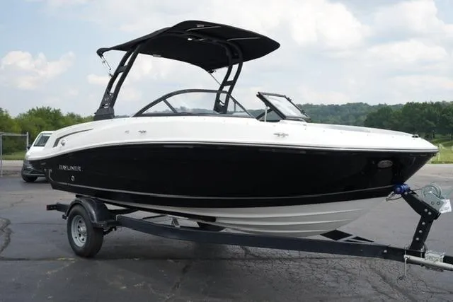 Slide: The Image of 2024 Bayliner VR5 Bowrider I/O on trailer, black and white design, parked outdoors. - 3