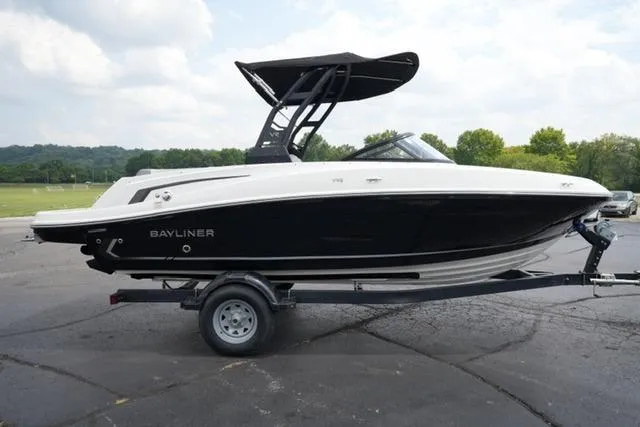 Slide: The Image of 2024 Bayliner VR5 Bowrider I/O boat on trailer, black and white design, parked outdoors. - 4