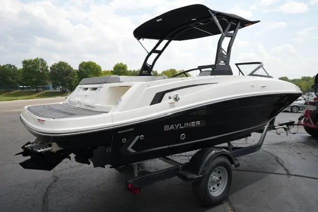 Slide: The Image of 2024 Bayliner VR5 Bowrider I/O on trailer, black and white design, parked outdoors. - 5