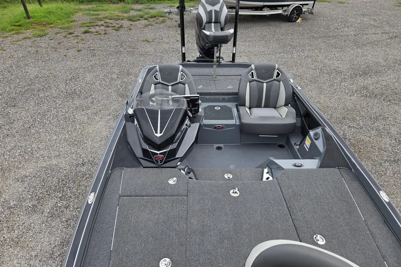 Slide: The Image of 2022 Ranger Z520R boat interior with seating and control panel, parked on gravel. - 15