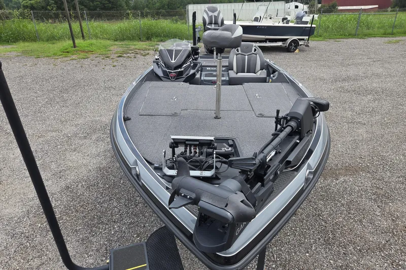 Slide: The Image of 2022 Ranger Z520R fishing boat with advanced equipment, parked on gravel near greenery. - 2