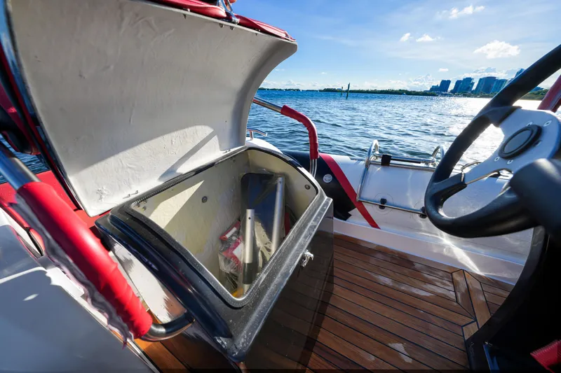 Slide: The Image of 2023 Trident 21 RIB boat with open storage compartment on a sunny day. - 11