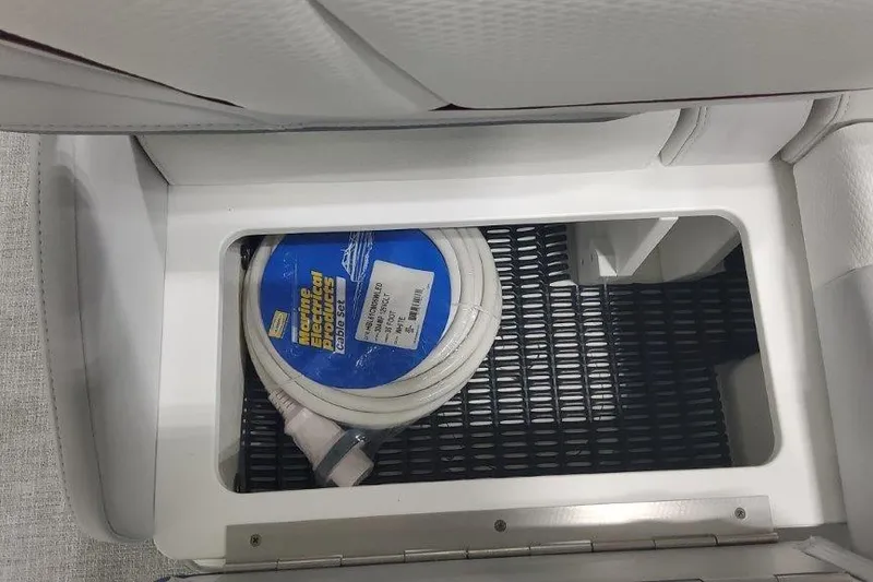 Slide: The Image of Storage compartment in 2024 Formula 310 Sun Sport boat with coiled marine electrical cable. - 26