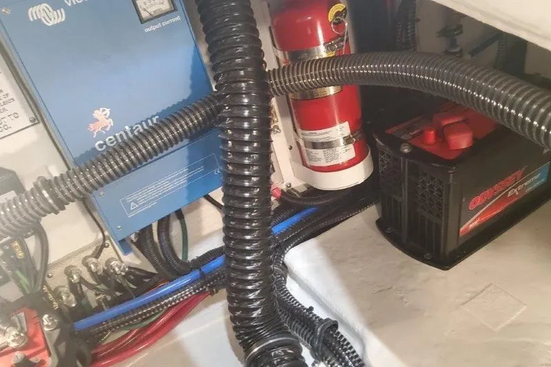 Slide: The Image of 2024 Formula 310 Sun Sport engine compartment with wiring, fire extinguisher, and battery. - 35