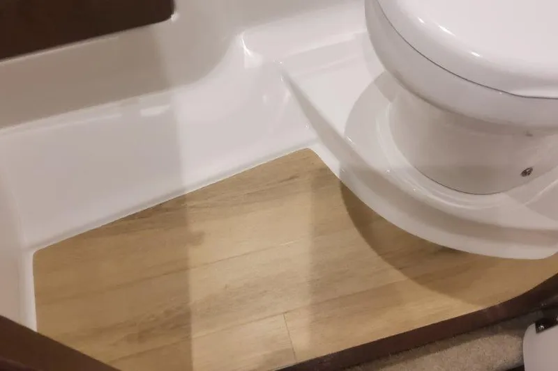 Slide: The Image of 2024 Formula 310 Sun Sport bathroom with wooden flooring and white toilet. - 48