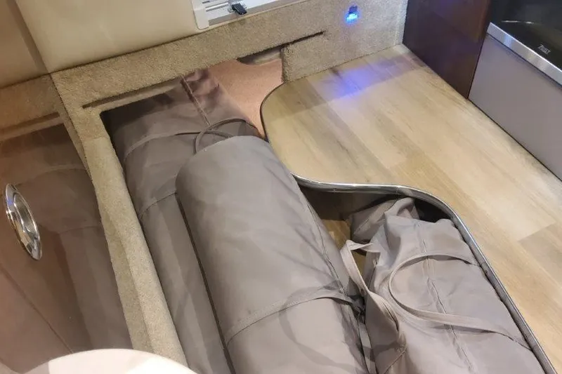 Slide: The Image of 2024 Formula 310 Sun Sport interior storage compartment with rolled-up covers. - 52