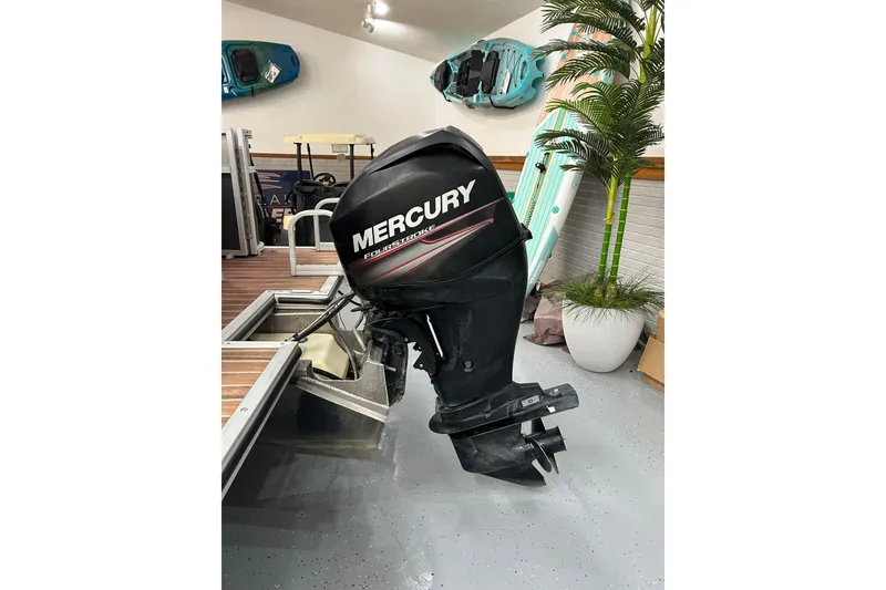 Slide: The Image of 2013 Crest Classic 230 with Mercury four-stroke outboard motor in showroom. - 2
