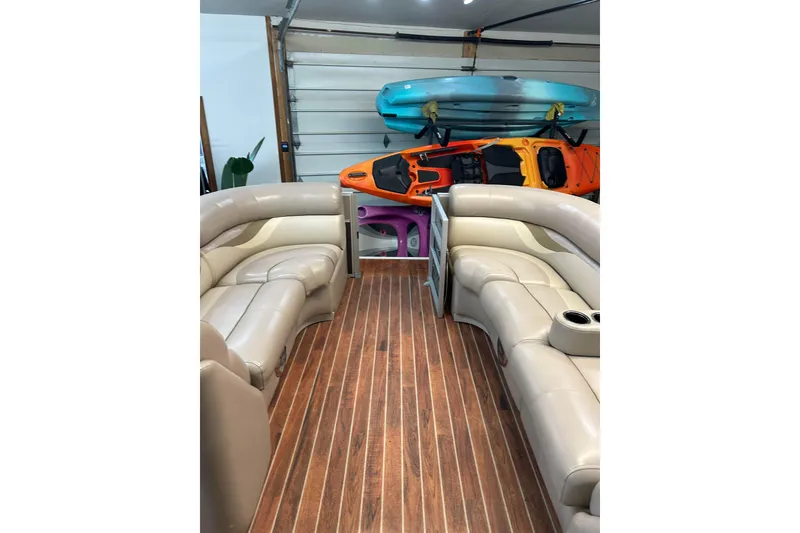 Slide: The Image of 2013 Crest Classic 230 pontoon boat interior with beige seating and wood flooring. - 4