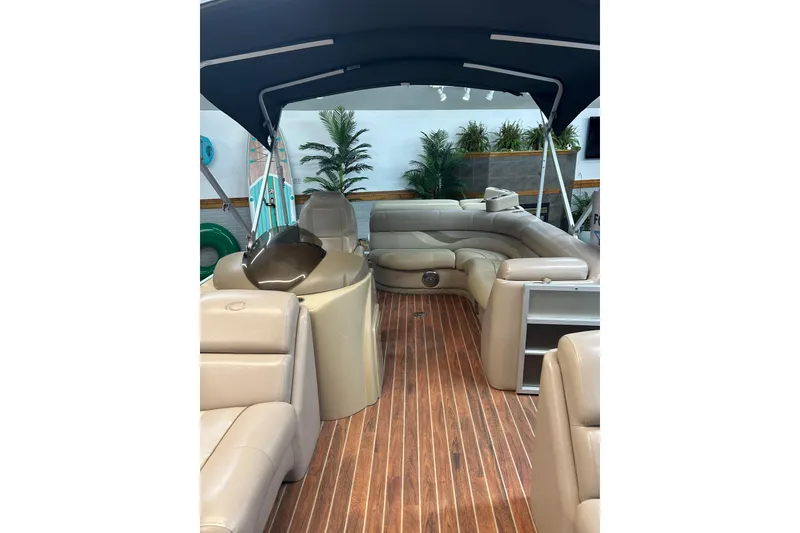 Slide: The Image of 2013 Crest Classic 230 pontoon boat interior with beige seating and wood flooring. - 5